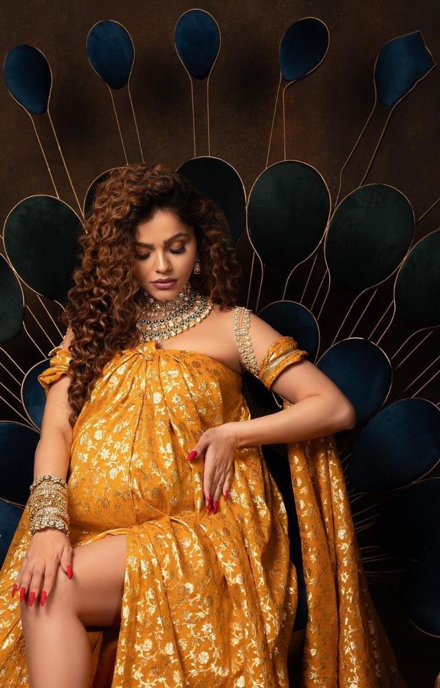 The flowy, cutout outfit allowed a glimpse of her growing baby bump