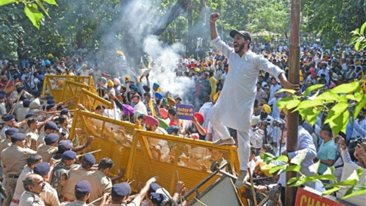 A water cannon doused flames from an effigy set on fire by AAP protesters in Chandigarh.