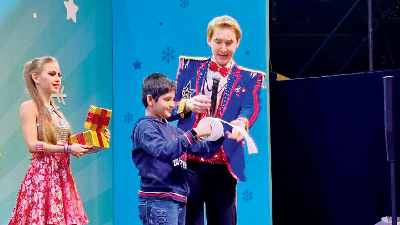 The magician shows a trick to a boy from the audience