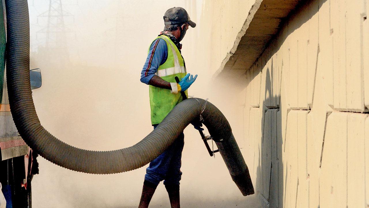 A BMC worker combats dust with a vacuum machine near Aarey Colony on April 26, 2020. File Pic/Satej Shinde