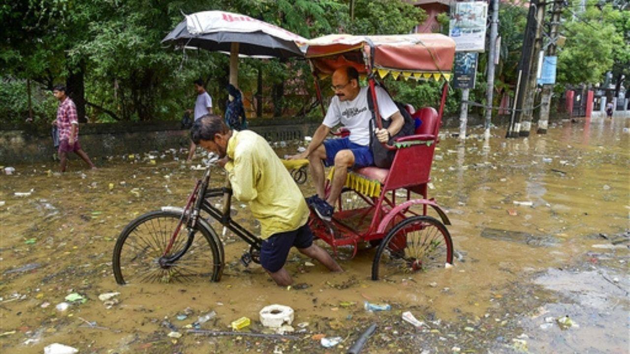 A rickshaw driver was spotted wading through the murky water with garbage floating atop. 