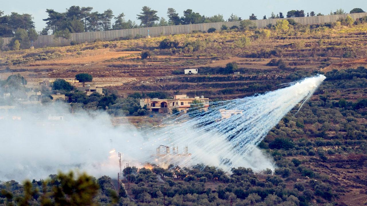 An Israeli artillery shell explodes over a house in a Lebanese border village. Pic/AP