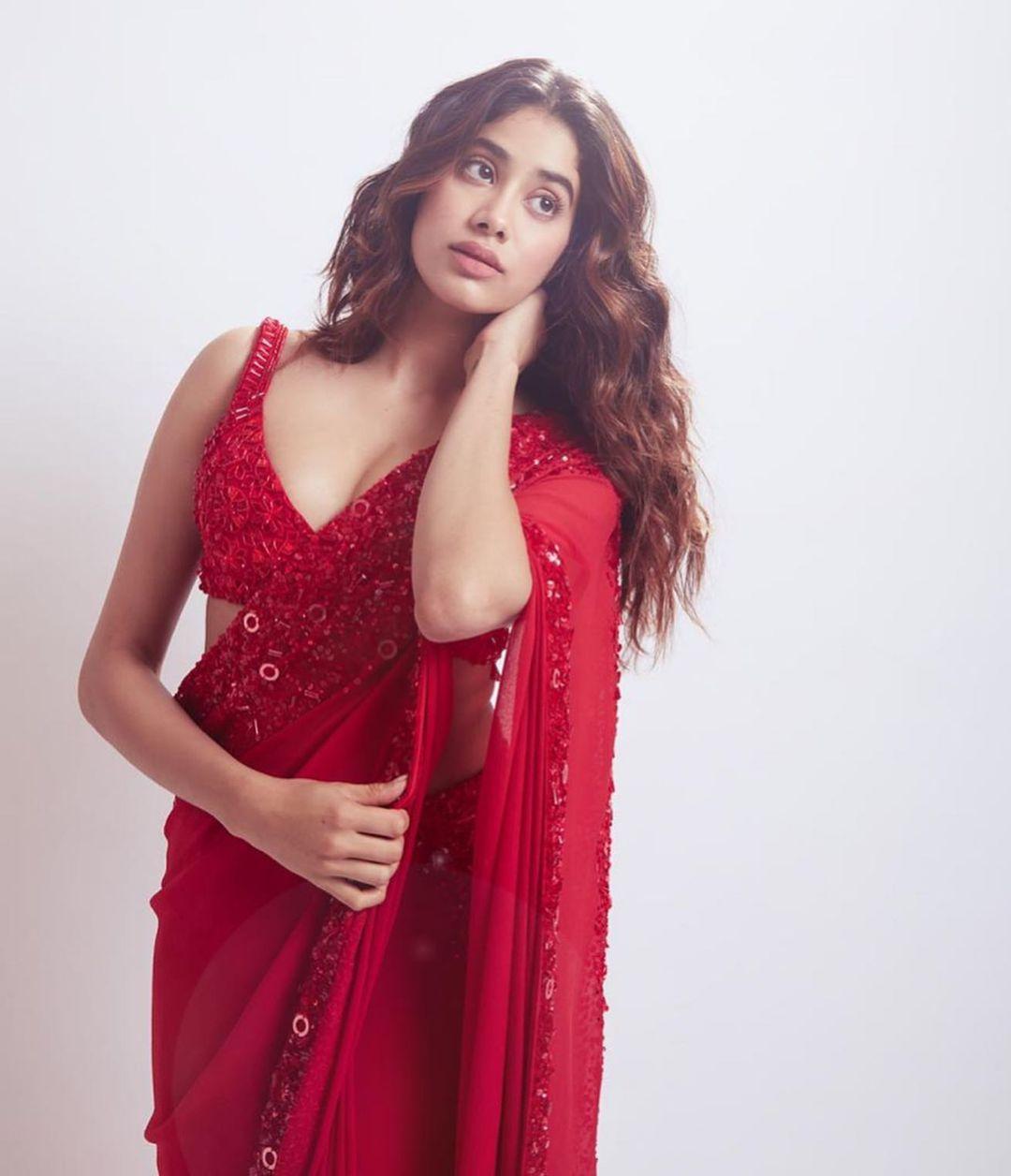 The georgette saree boasts a semi-sheer silhouette, adorned with delicate lace-trimmed floral borders and shimmering red sequin embellishments.