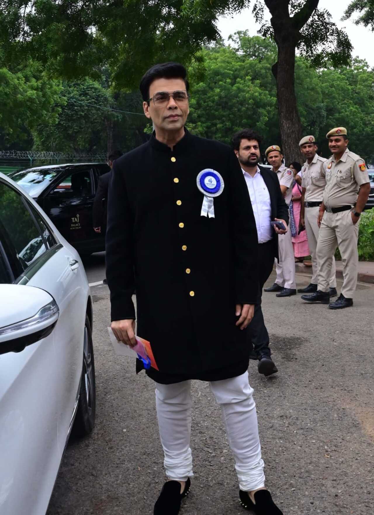 Karan wore a black suit paired with matching shoes and white pyjamas