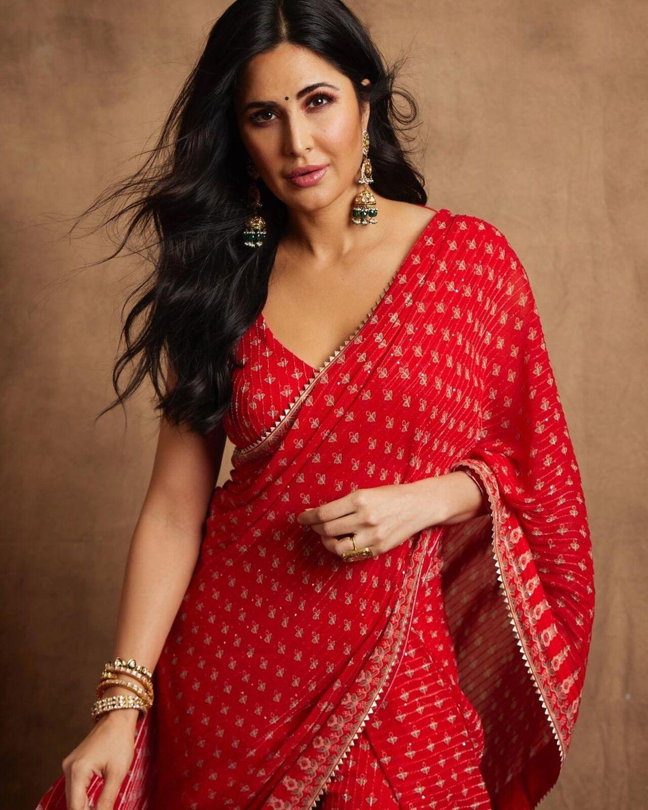 The actress wore contrasting green jhumkas with her red saree as she posed for the camera