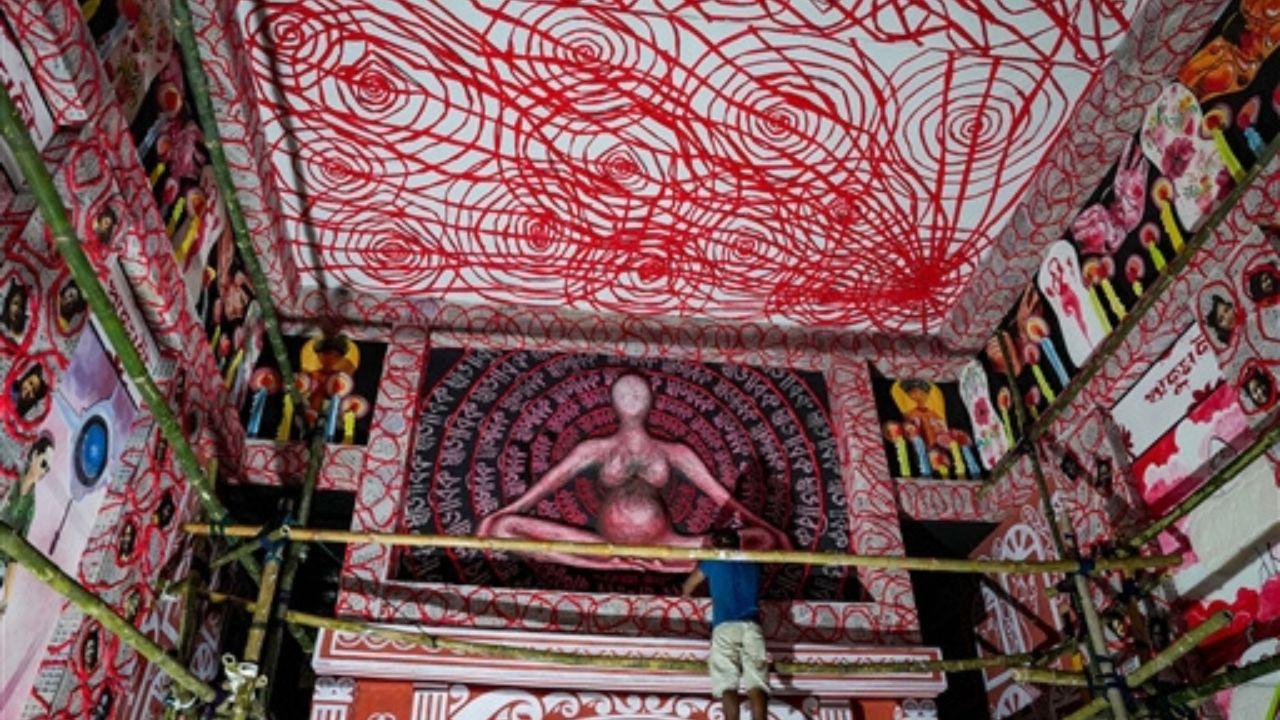 In another pandal, a worker was installing an artwork at a pandal with the theme of menstrual hygiene
