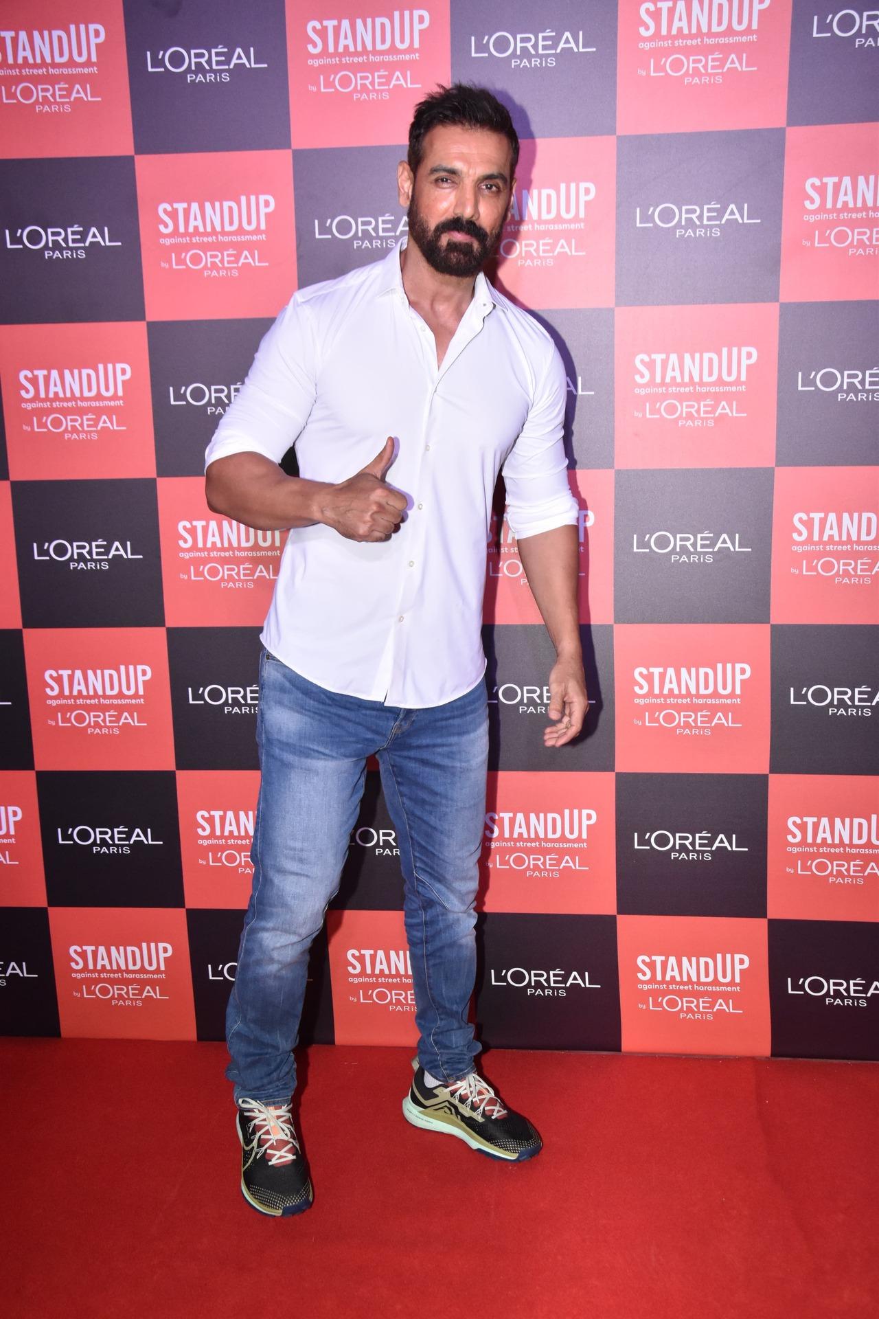 John Abraham kept it simple in a white shirt and blue denims as he posed for the paparazzi with his trademark thumbs up mark