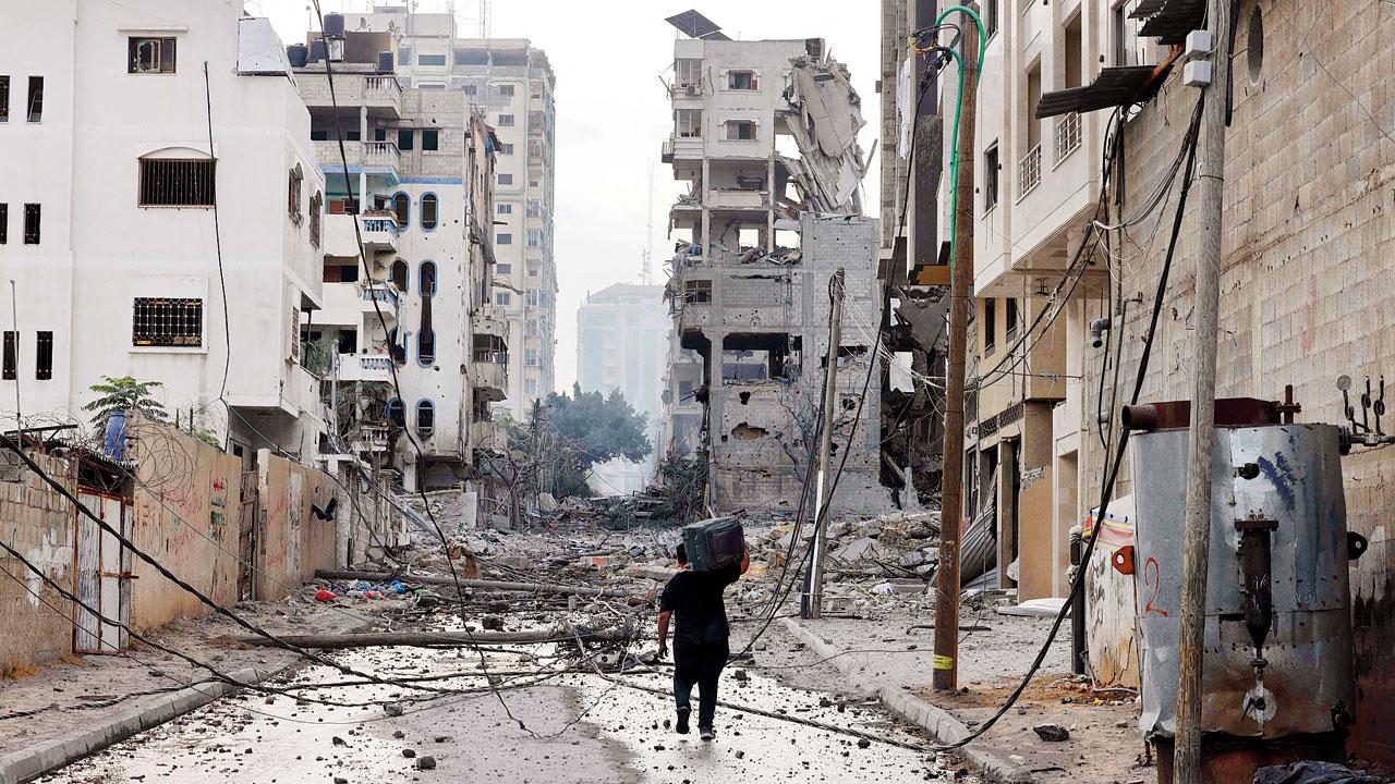 A Palestinian man leaves with a suitcase on his shoulders. Pic/AP