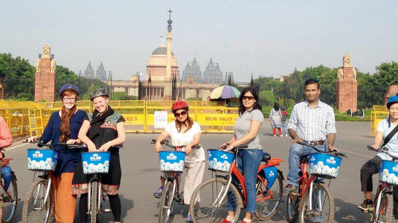 Delhi By Cycle completes 15 years in 2024. Seen here is a group in front of Rashtrapati Bhavan with barricades in the immediate background