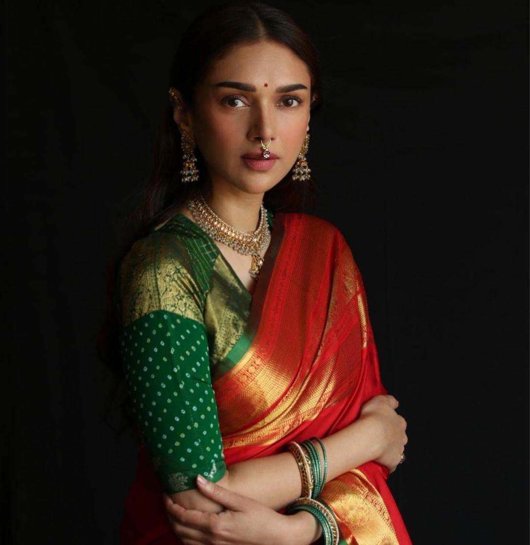 Aditi Rao Hydari looks stunning in a red saree with a green blouse. 