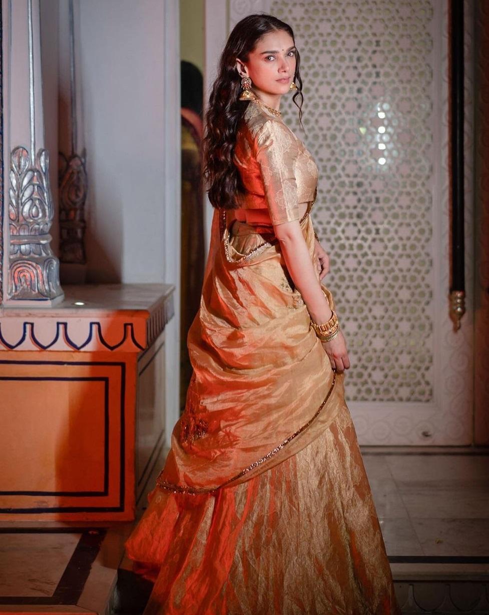 She looks angelic in a half-sleeve blouse in the same colour as her golden brocade lehenga.