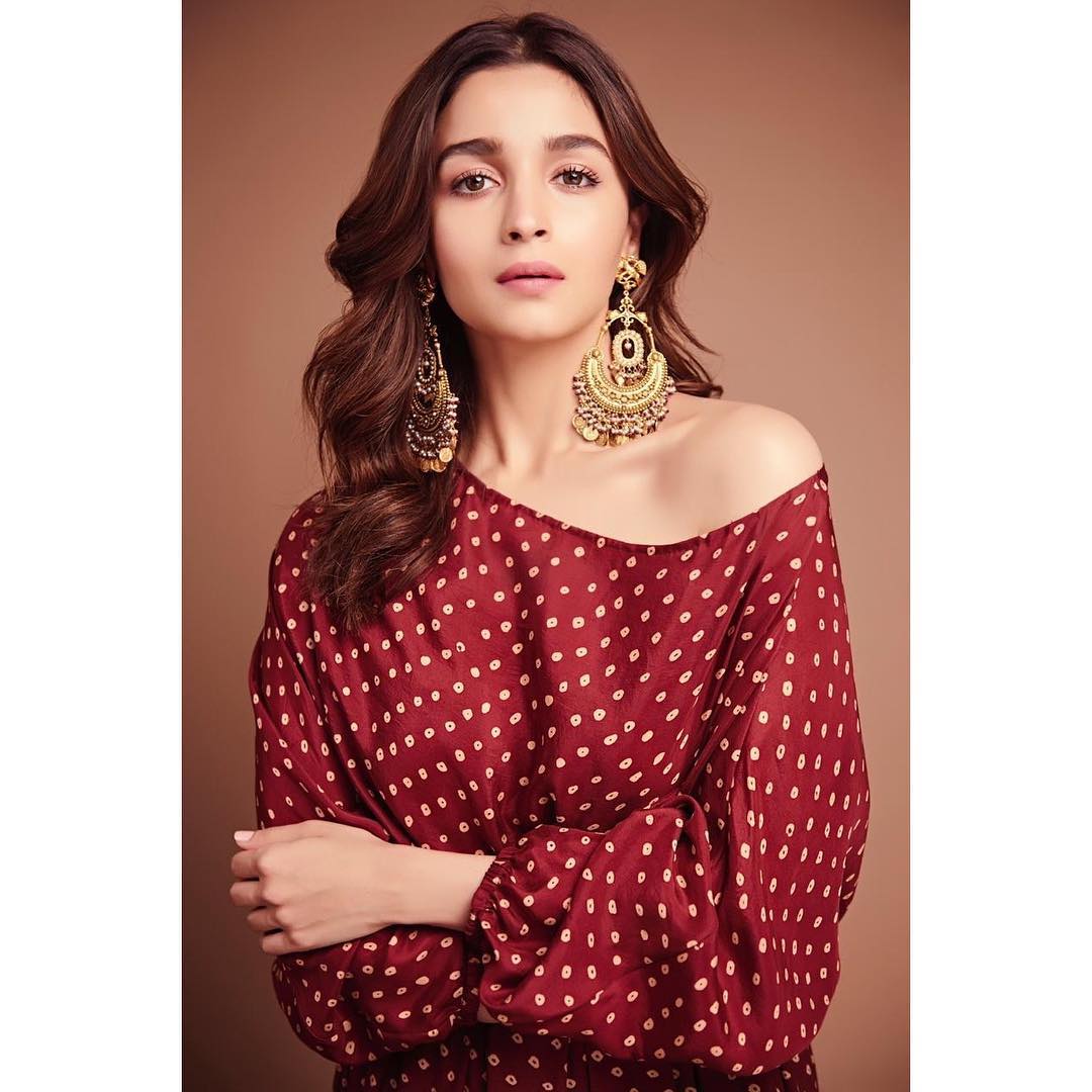 Alia Bhatt is our style icon, shining in a maroon one-shoulder gown that exudes elegance. She completes the look with beautiful chandbalis and strappy sandals, striking a perfect balance between traditional and modern.