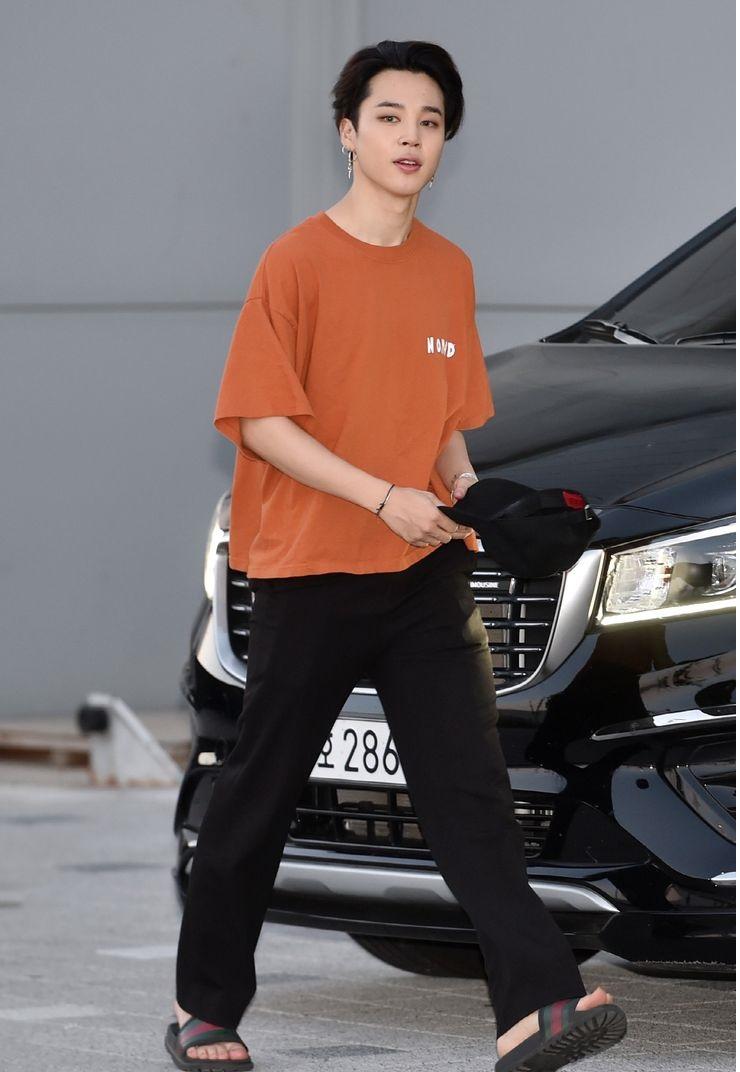 Jimin's casual outfit of an orange t-shirt and black tracks is a testament to his laid-back style. It's all about comfort without compromising on fashion.