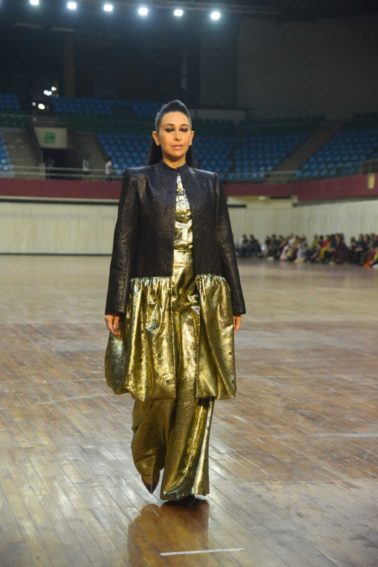 Karisma wore a black and golden dramatic pantsuit. It came with a bandhgala style coat which extended into a front-open flared skirt. She completed her look with golden pants