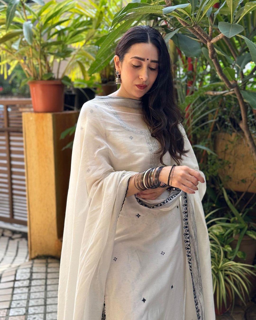 Sasthi On Sastami, you can don this Karisma Kapoor look. This white salwar set is the perfect outfit for the occasion, combining tradition with modern flair. 