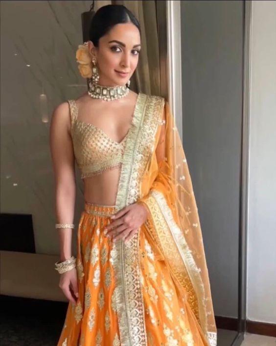 Kiara Advani looked absolutely stunning as a bridesmaid in her orange and gold embellished lehenga. She paired it with a bralette and a zari dupatta.