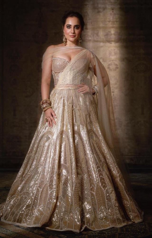The lehenga is paired with a beautifully detailed corset and a stylish drape, making her look like a true fashion icon.