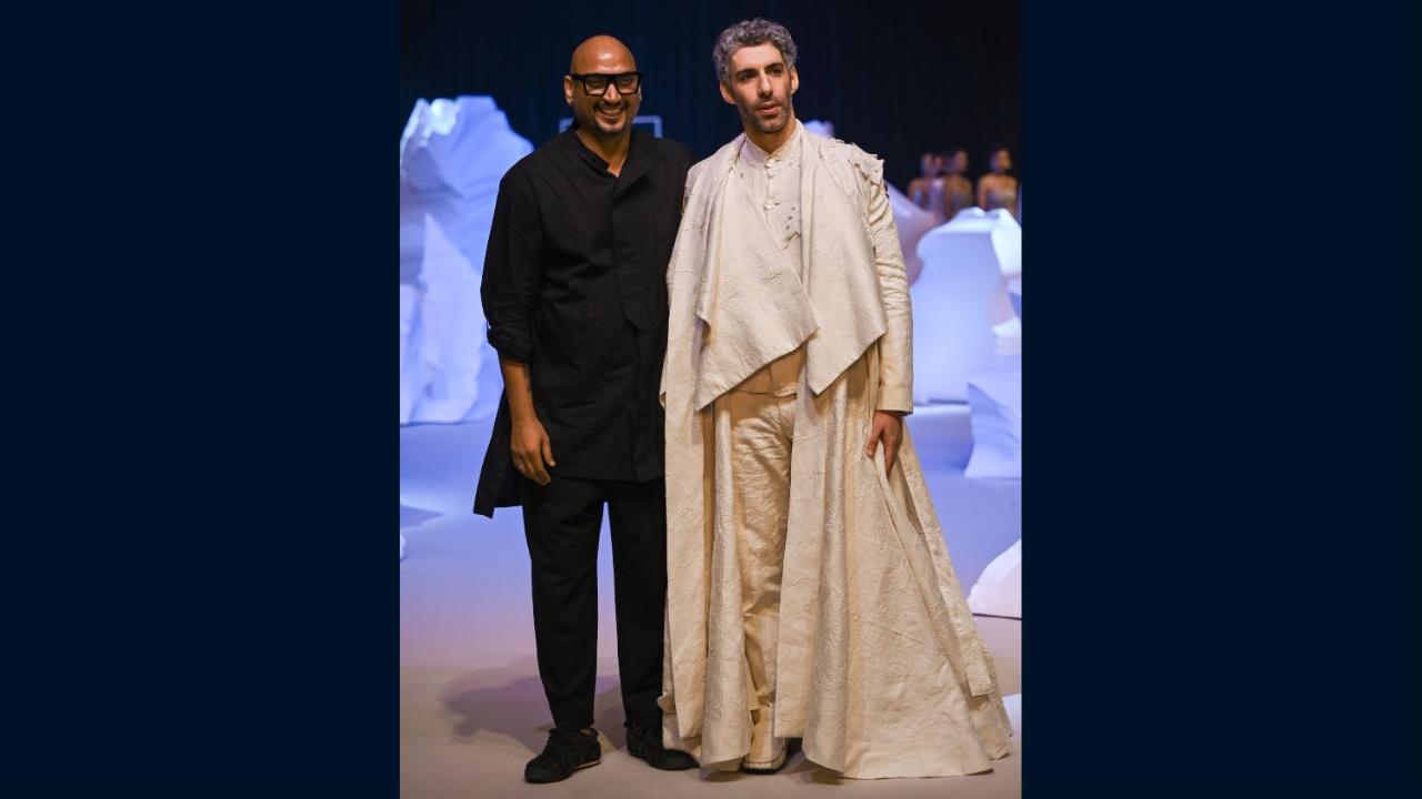 Bollywood’s hot star, Jim Sarbh stopped the very dramatic show in an all-white, layered, look. A regal floor-sweeping, flared, trench coat with fluid, impressive lapels, embellished with tonal embroidery and appliqués was worn over a mandarin collar shirt and white trousers