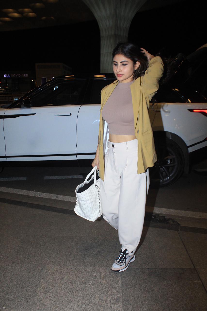 Mouni Roy was spotted at the airport wearing a pair of white pants paired with a crop top and a yellow shirt
