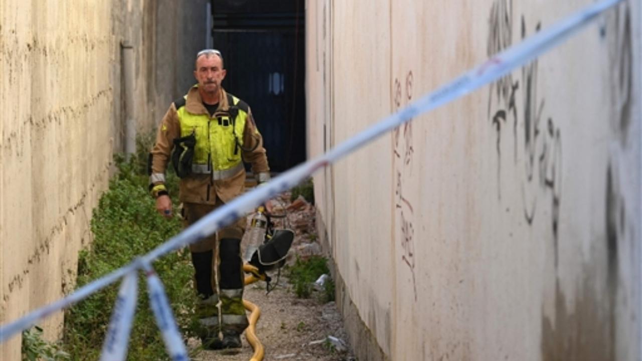 A firefighter leaves the building where at least thirteen people were killed in a fire at a nightclub in Murcia