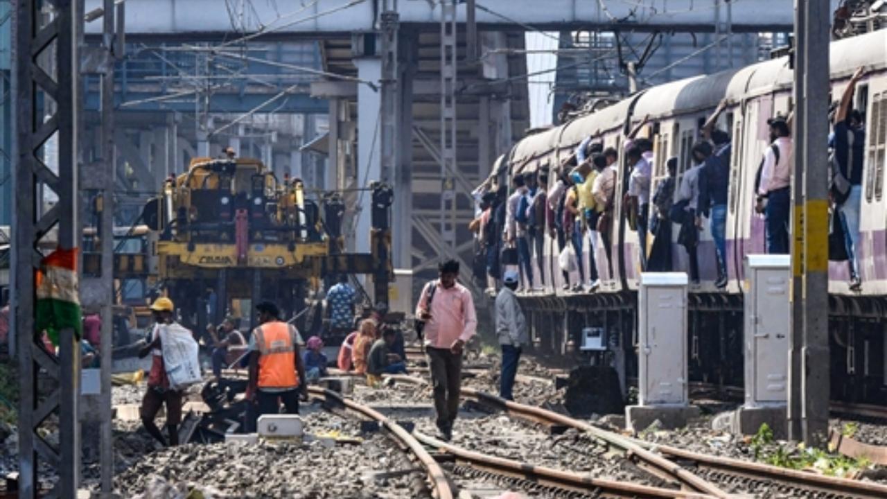 A trains passes as workers construct the sixth line between Khar and Goregaon stations at Andheri railway station in Mumbai