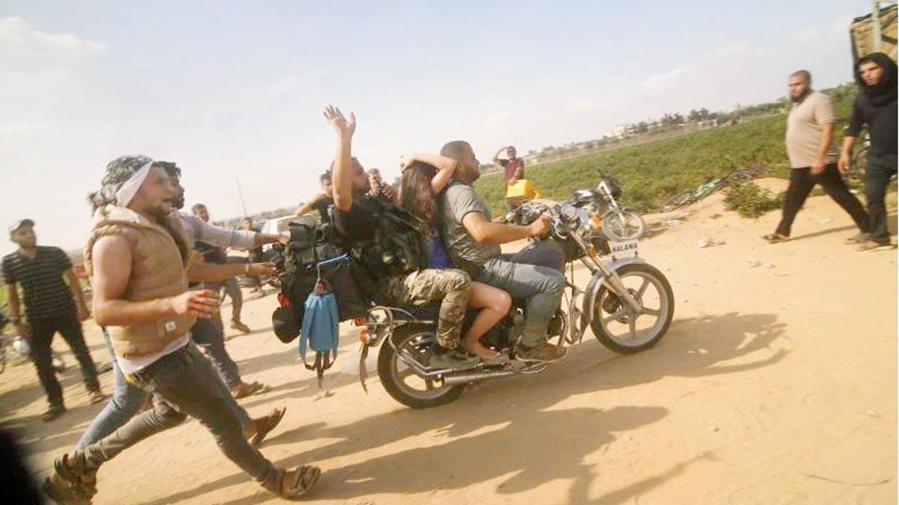 A captured Israeli civilian (center) being taken into the Gaza Strip