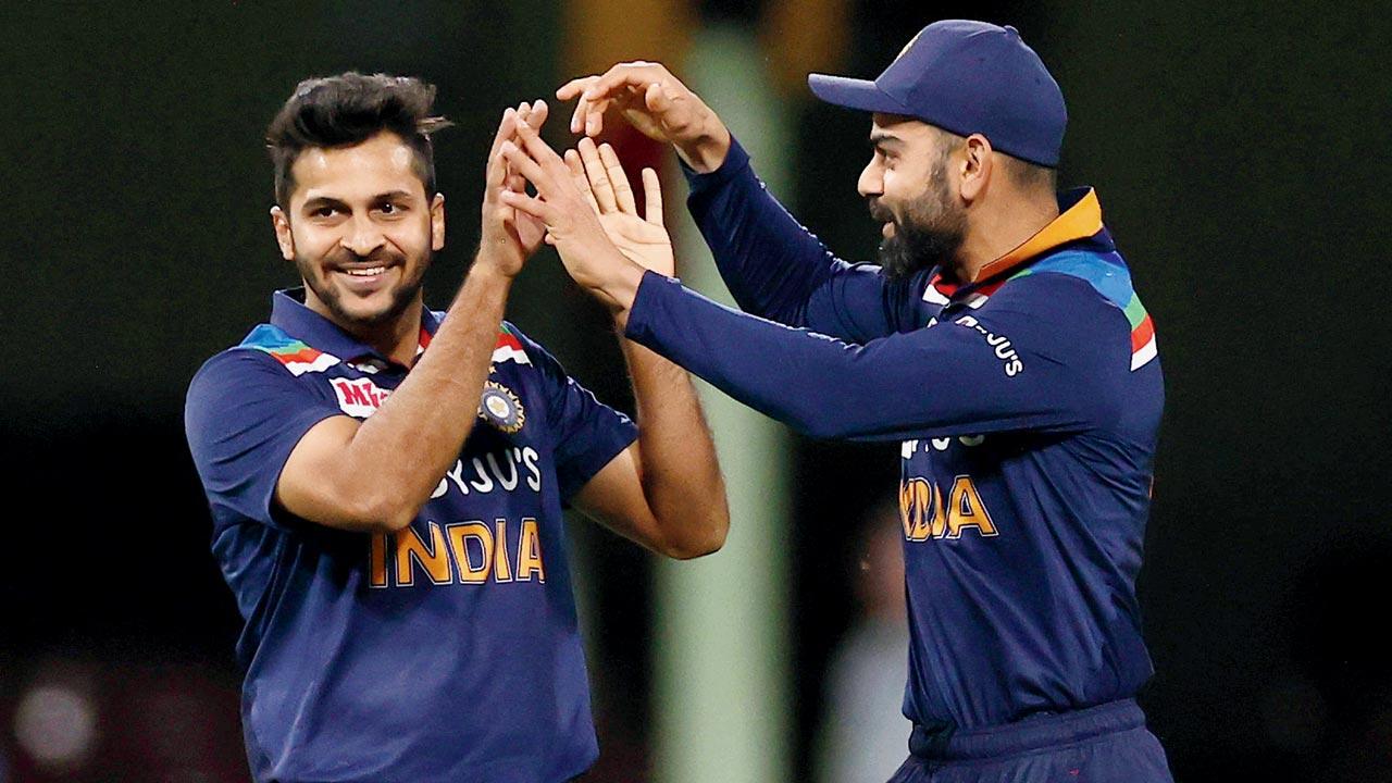 Shardul Thakur and Virat Kohli celebrate after the former took the wicket of Glenn Maxwell of Australia during game two of the Twenty20 International series between Australia and India at Sydney Cricket Ground on December 6, 2020 in Sydney, Australia. Pic/Getty Images