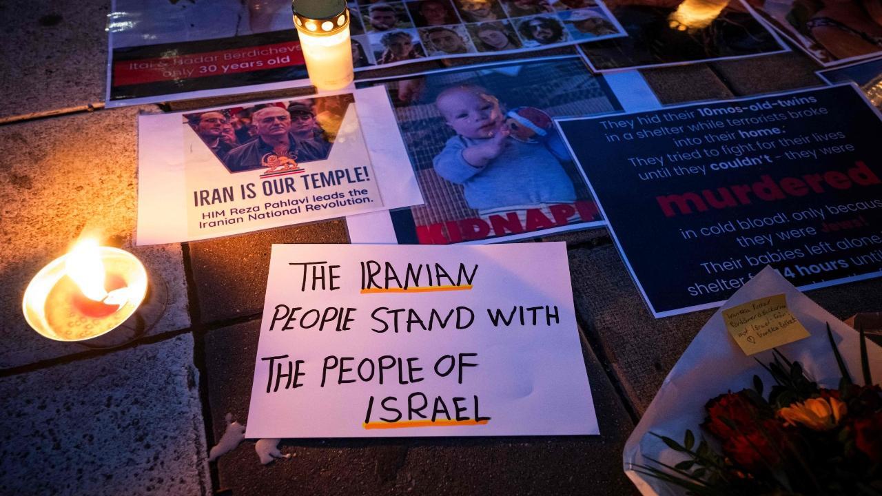 A letter reads 'The Iranian people stand with the people of Israel' as images of victims of the October 7 attack in Israel are shown during a demonstration in support of Israel, in Stockholm, Sweden on October 11, 2023. Pic/AFP