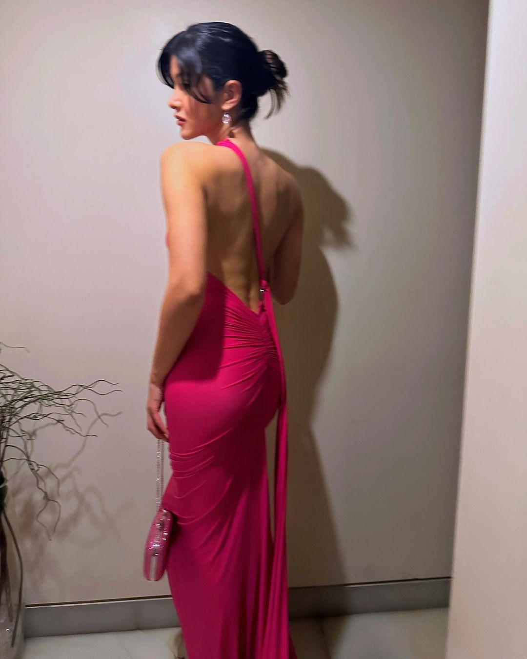 The dress's backless style and ruched details added a touch of drama to her appearance.