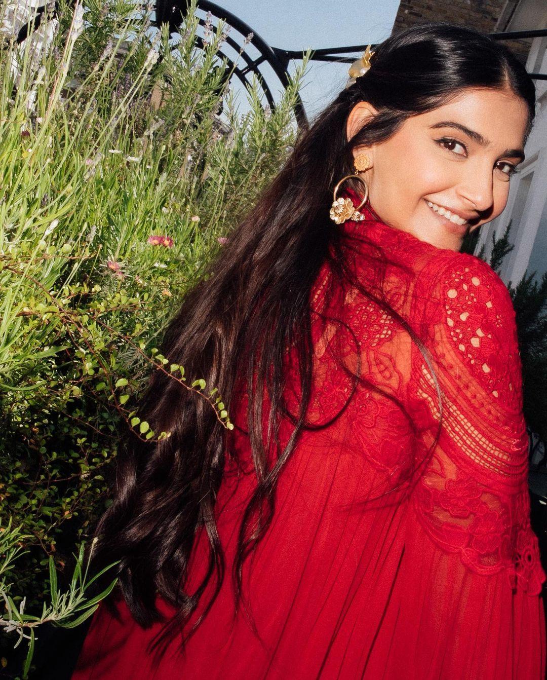 Sonam Kapoor's birthday outfit is perfect for Diwali. She wore a stunning ruby red dress from the Greek designer Christos Costarellos' brand, Costarellos. This dress is made of silk chiffon with a high neck and beautiful lace embroidery on the upper half of the bell sleeves and above the bust.