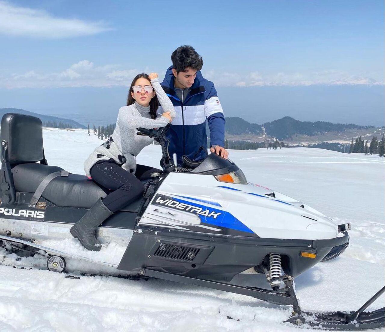 In this image, Sara confidently struck a stylish pose in a grey turtleneck sweater and black jeans, while Ibrahim sported a smart jacket. The photo was captured against the stunning backdrop of a snowy landscape