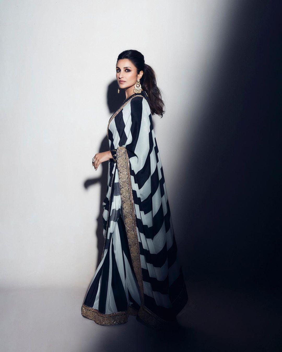 This black and white saree with a heavy border can make you effortlessly stand out in the crowd. Its simple print maintains a sense of sophistication, while the addition of heavy jhumkas infuses a touch of glamour to complete the look