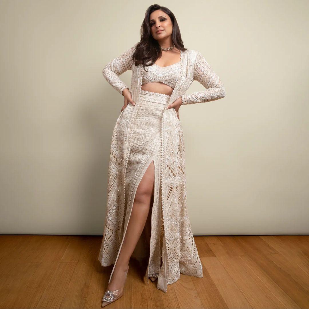  Let Parineeti's fashion sense guide you in selecting the perfect ensemble for your special occasion. The actress turned heads in a stunning crop top, elegantly complemented by a thigh-slit skirt, and completed her look with a matching shrug, exuding absolute style and grace