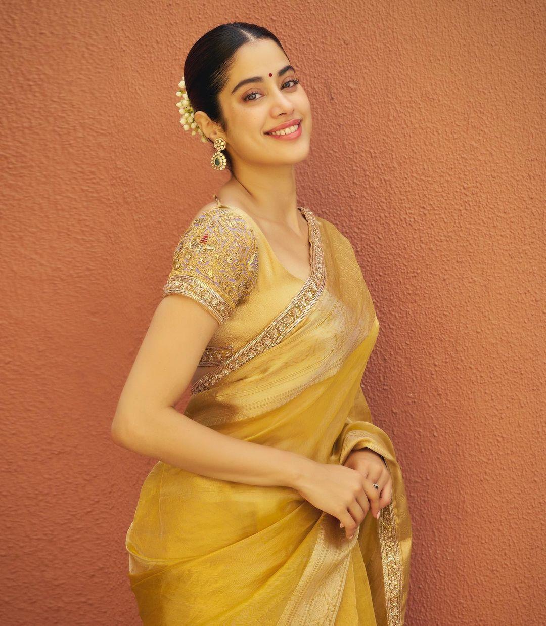 Janhvi Kapoor's choice of a vintage gold pure woven tissue saree hand-embroidered with original zari by @manishmalhotraworld for Ganesh Chaturthi exudes grace, paired with uncut and Russian emerald earrings from @manishmalhotrajewellery.