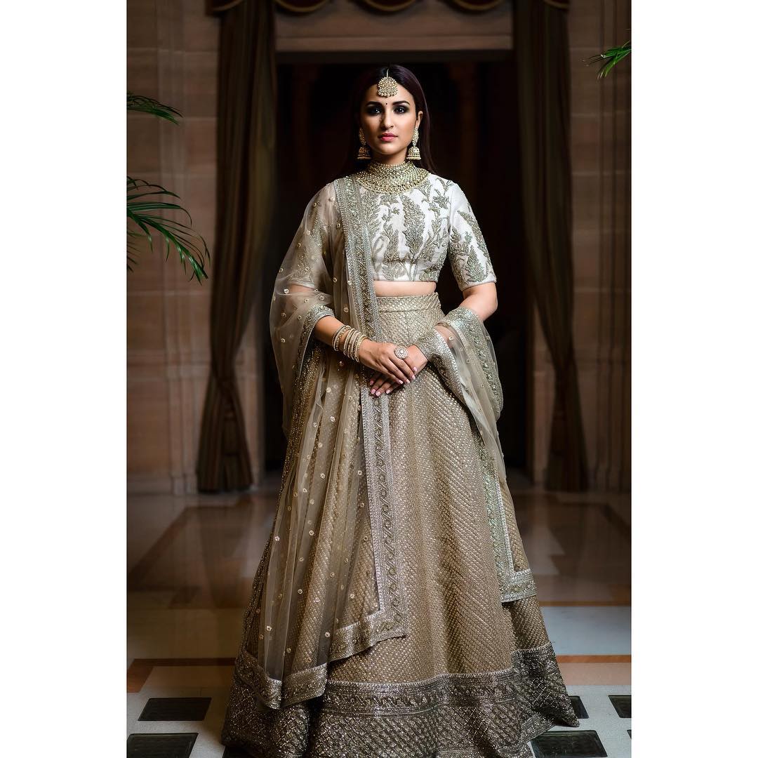 It's a family wedding, and you don't want to wear the same old red-coloured dresses? Look no further, as Parineeti's ivory-coloured lehenga is a perfect choice to make yourself look perfect
