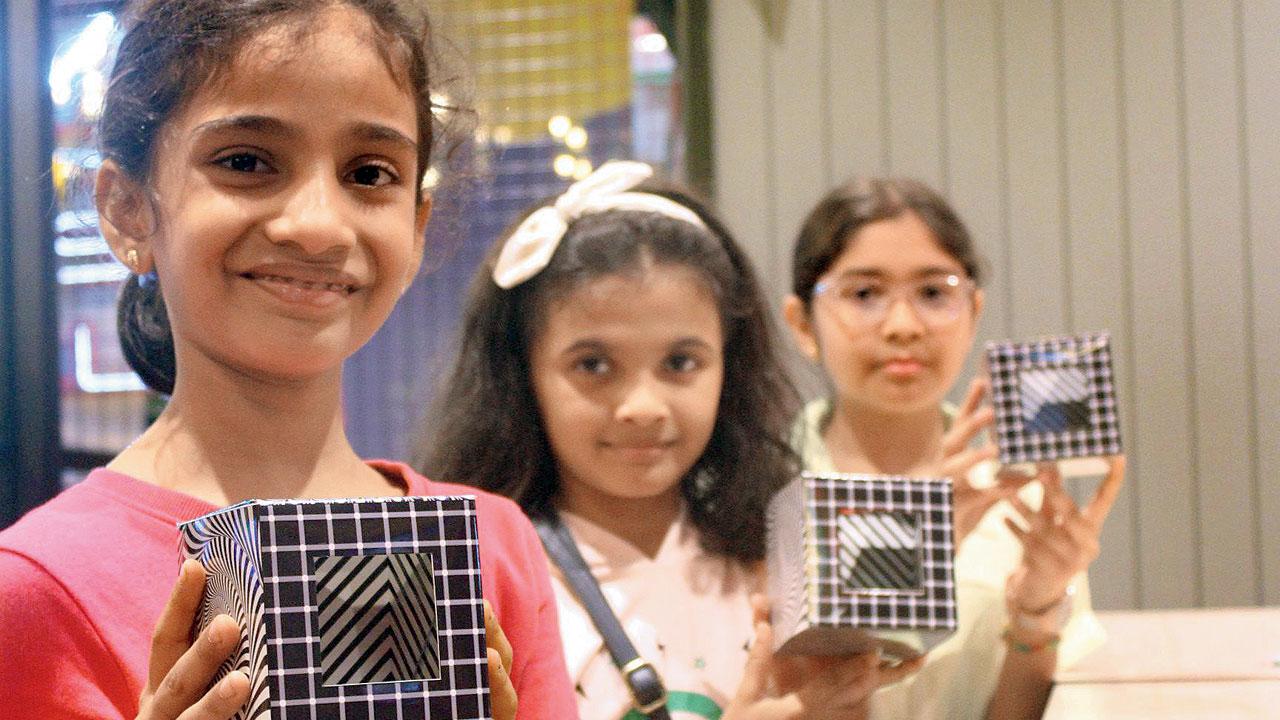 Children hold up the magical toy boxes that they created at one of the previous science fairs