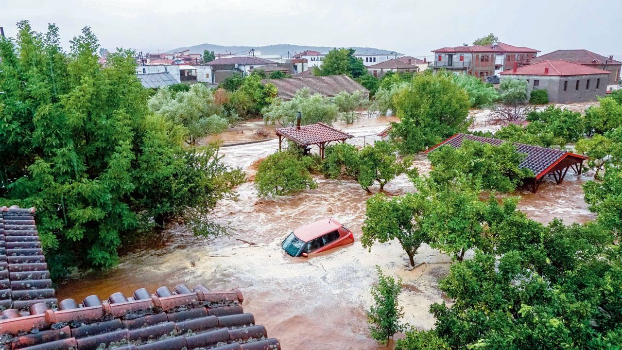 A car and houses submerged in a flooded area. Pic/AP