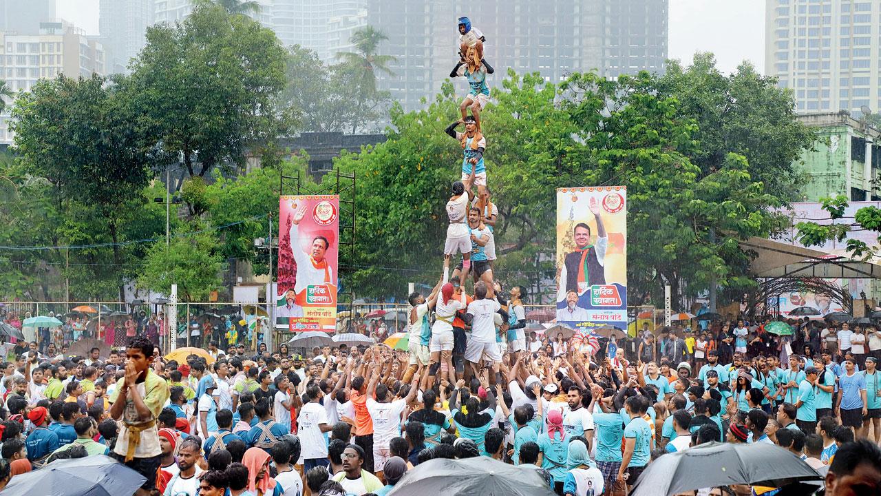 Posters of Devendra Fadnavis and other BJP leaders in the background at the Jambori Maidan Dahi Handi celebration at Worli on Thursday. Pic/Shadab Khan