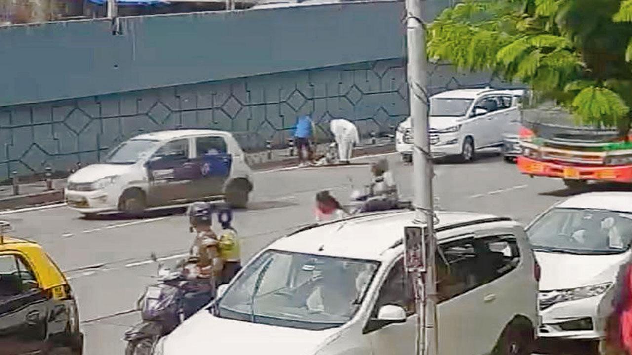 Ismail Ansari and a passer-by seen trying to help Pushpa Keni