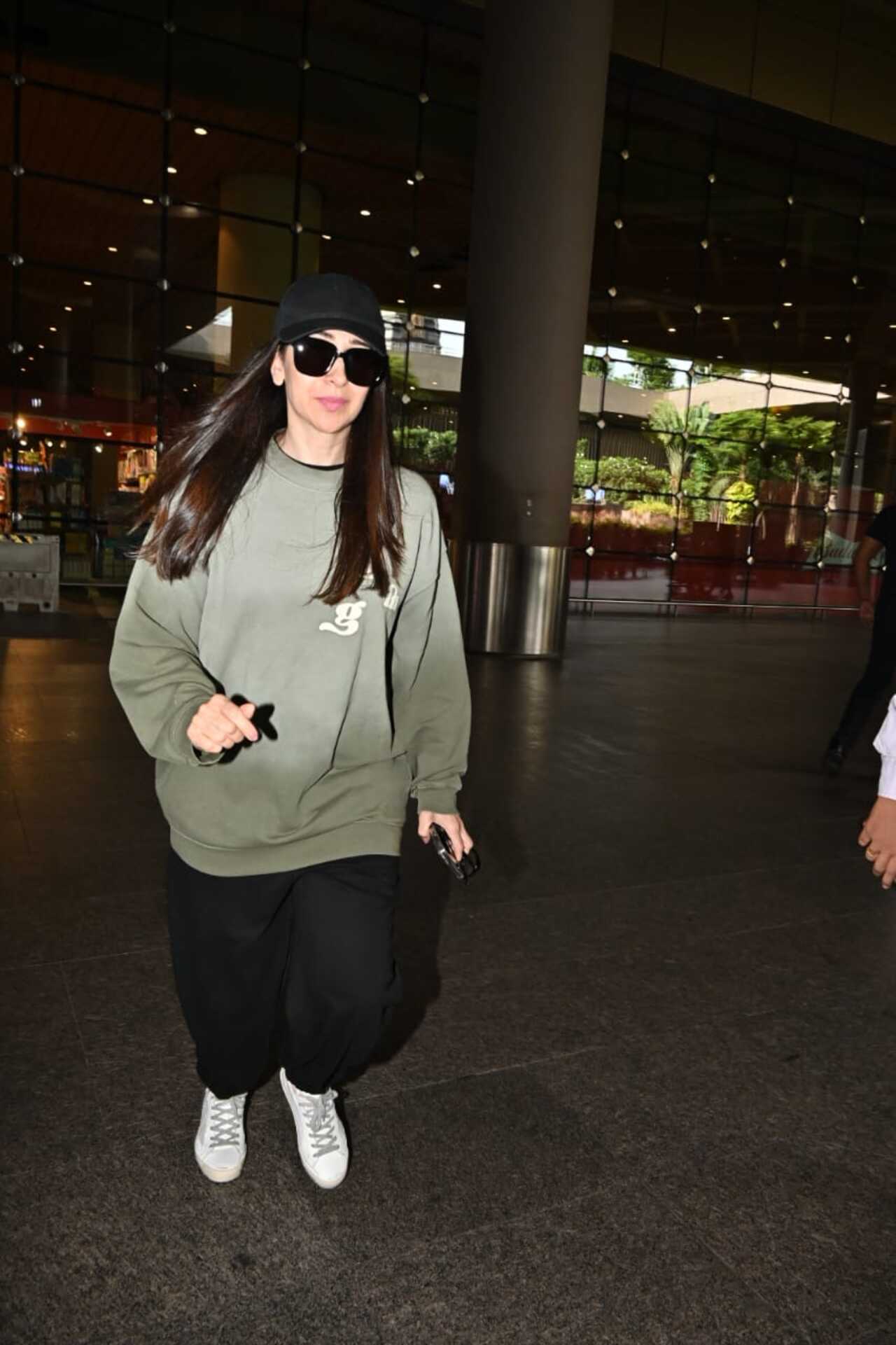 Karisma looked smart in a green hoodie paired with comfy black bottoms and a matching hat