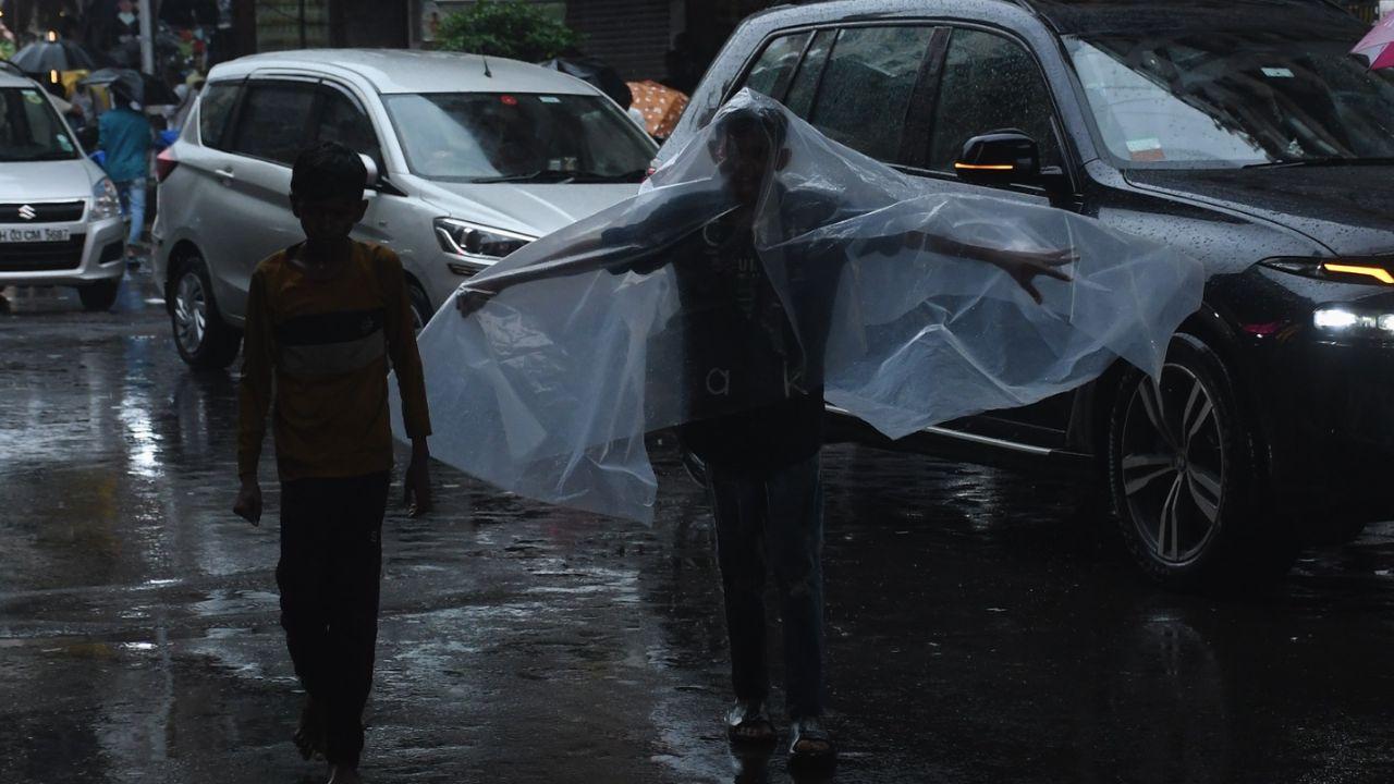 Another kid, covered in plastic sheet for cover from rain, was trying to channel his inner Batman as he walked through the city street with his Robin. 