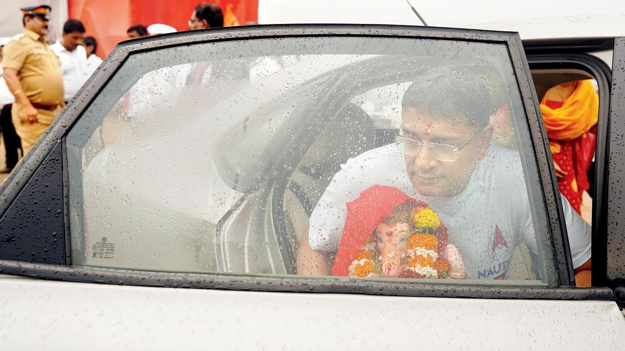 A family brings an idol of the beloved deity to Juhu beach amid rainfall. Pic/Aishwarya Deodhar