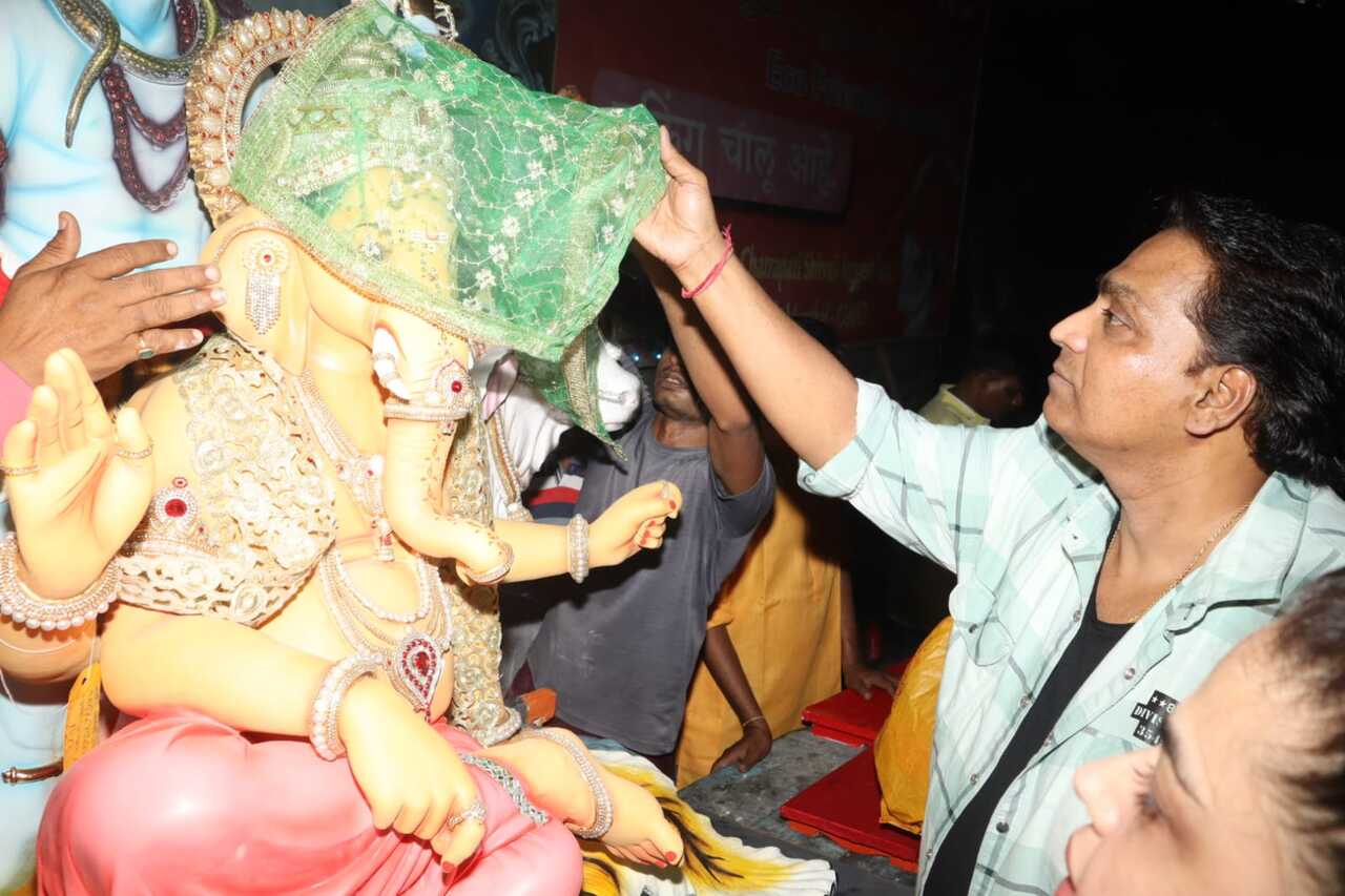 Choreographer Ganesh Acharya covers the face of a Ganpati idol as he brings the Lord to his house