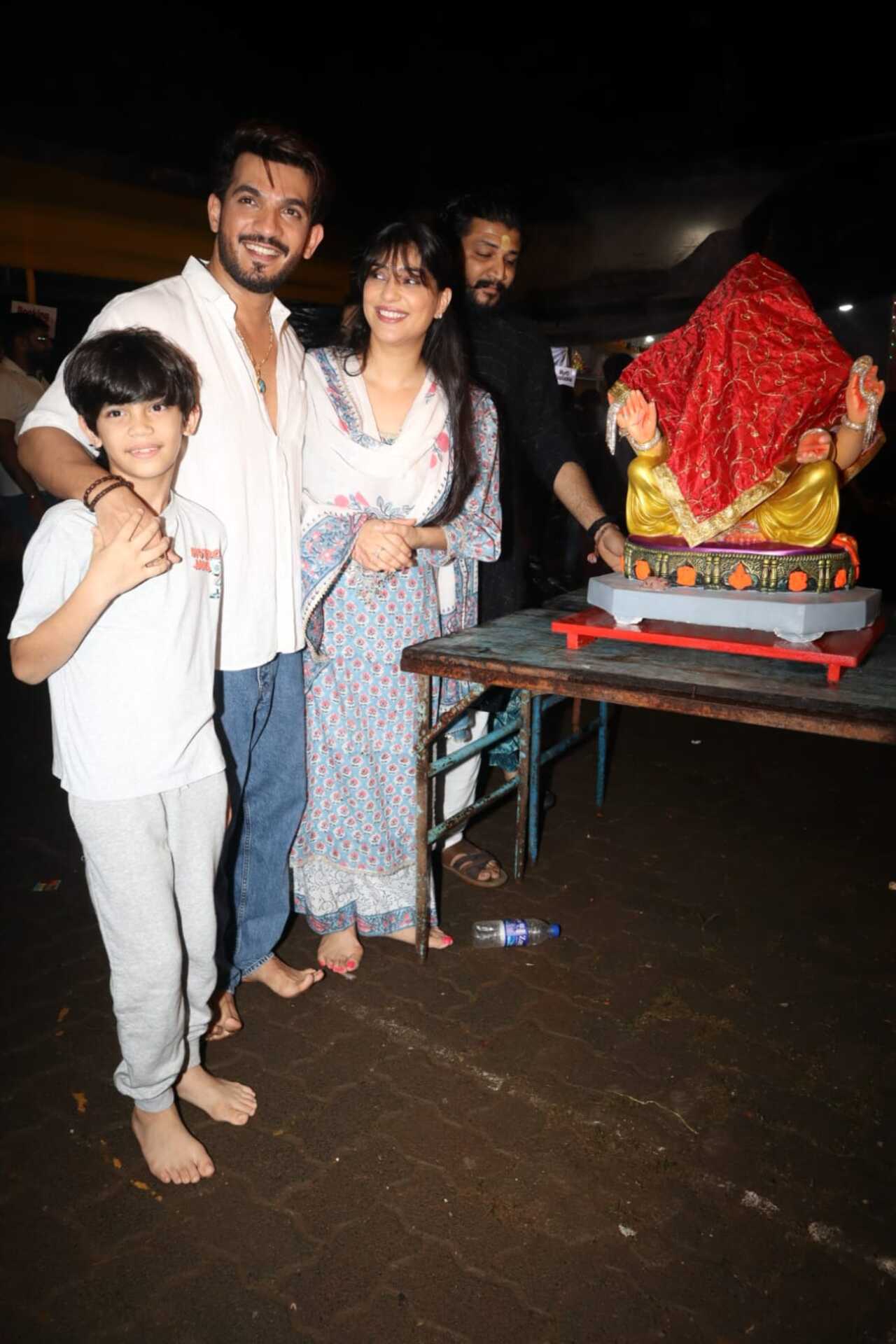 Arjun poses with his wife and son as the paps click them