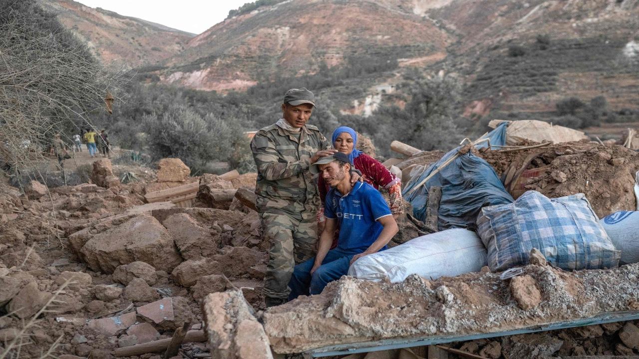 A Moroccan soldier takes cares for a man sitting on rubble in the mountainous area of Tizi N'Test, in the Taroudant province, one of the most devastated in quake-hit Morocco. 