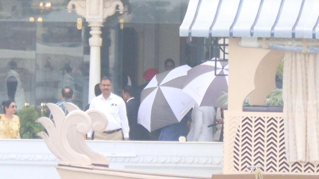Raghav Chadha was spotted in a white outfit hours before the wedding ceremony. He was being shielded by large umbrellas