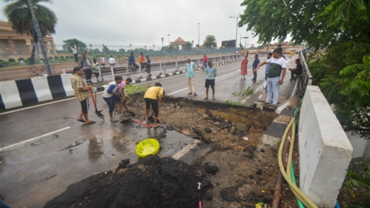 Workers engaged in repairment of a road which damaged due to heavy rainfall, in Lucknow