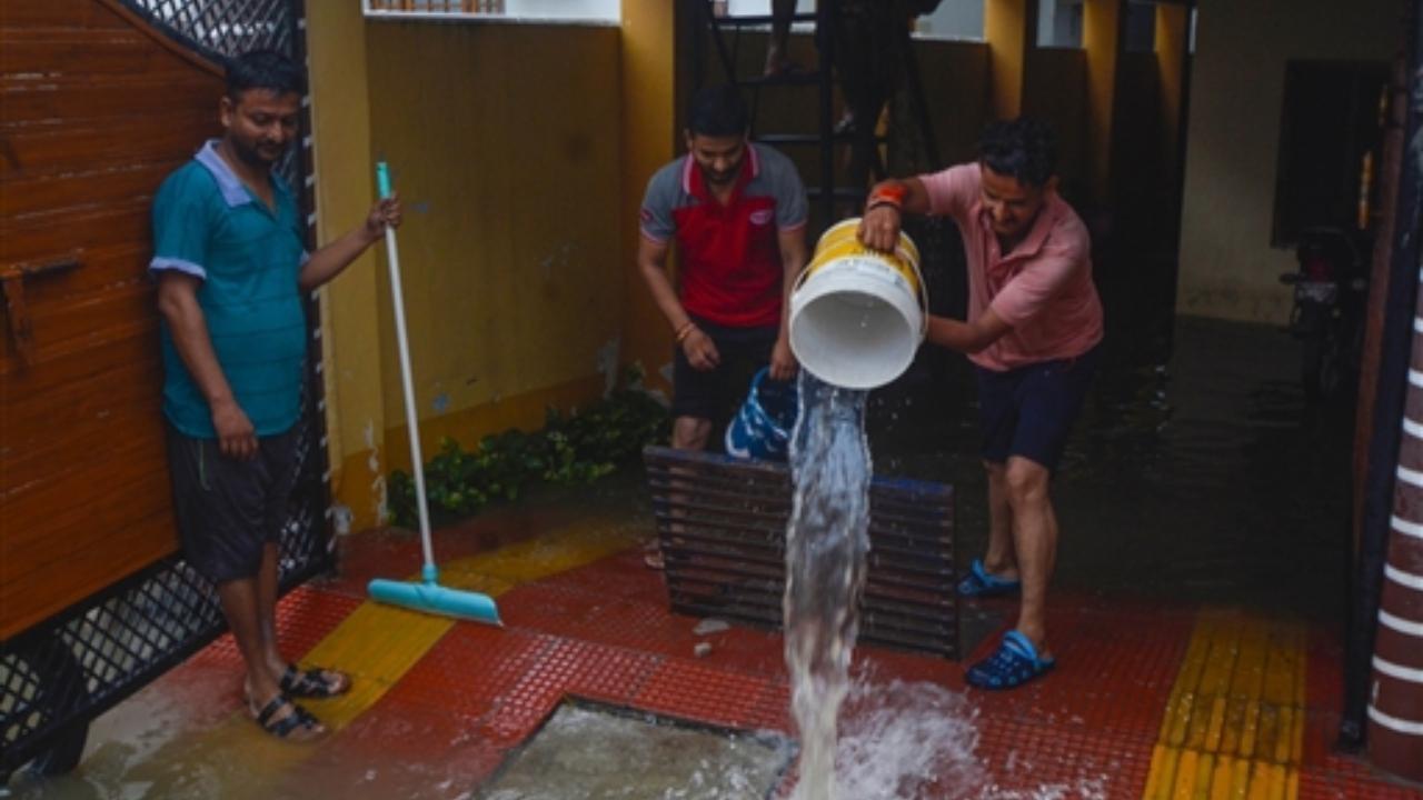 Residents clear rainwater from their house after heavy downpour, in Lucknow (Pic/PTI)