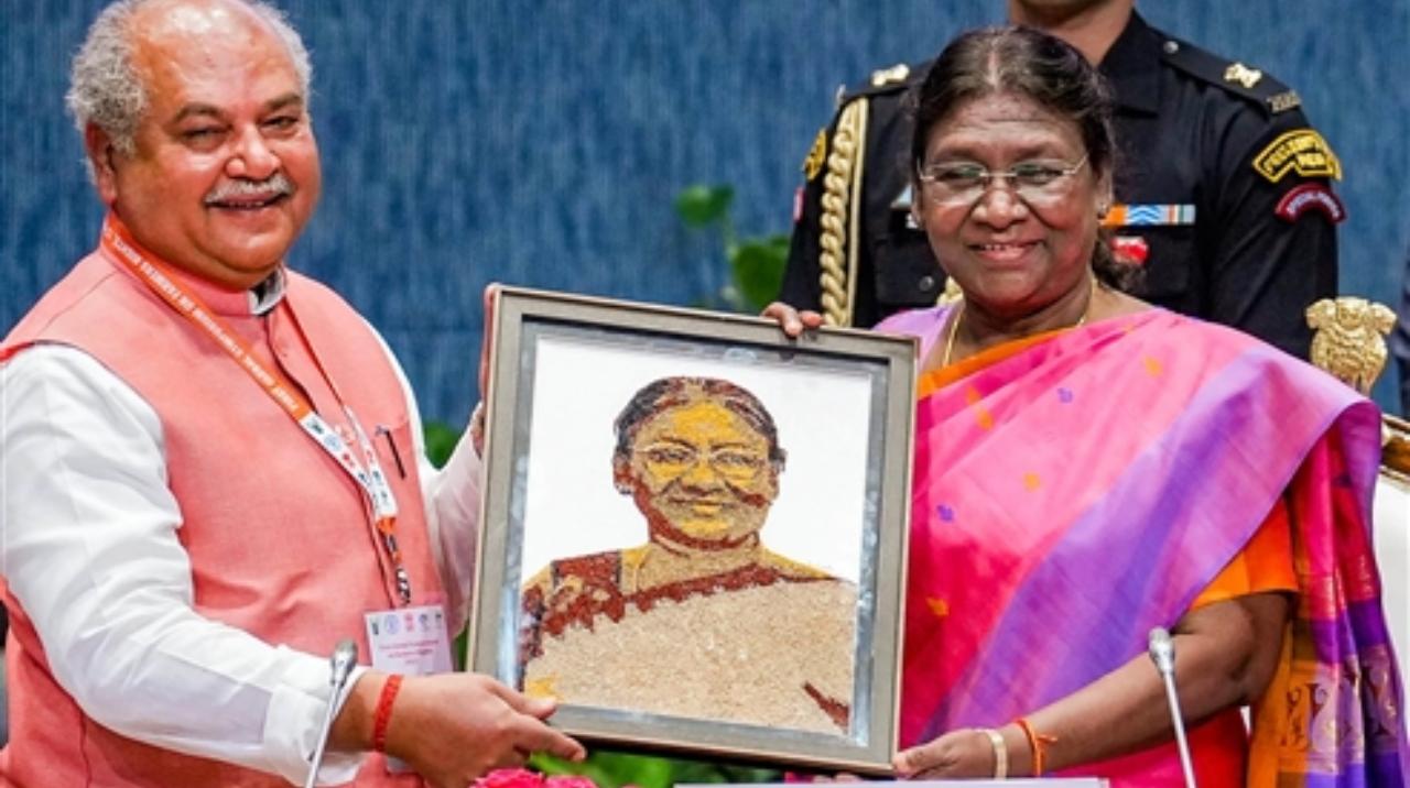 President Droupadi Murmu receives her portrait by Union Minister of Agriculture and Farmers’ Welfare Narendra Singh Tomar during the inauguration of the Global Symposium on Farmer's Rights