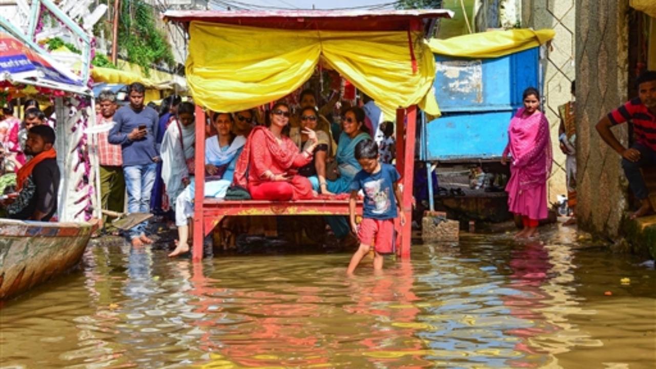Locals at a flood-affected area after opening of the Bargi dam gate of the River Narmada at Gwarighat, in Jabalpur